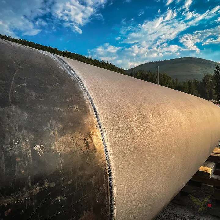 Coated large-diameter pipe staged on skids at a pipeline right-of-way