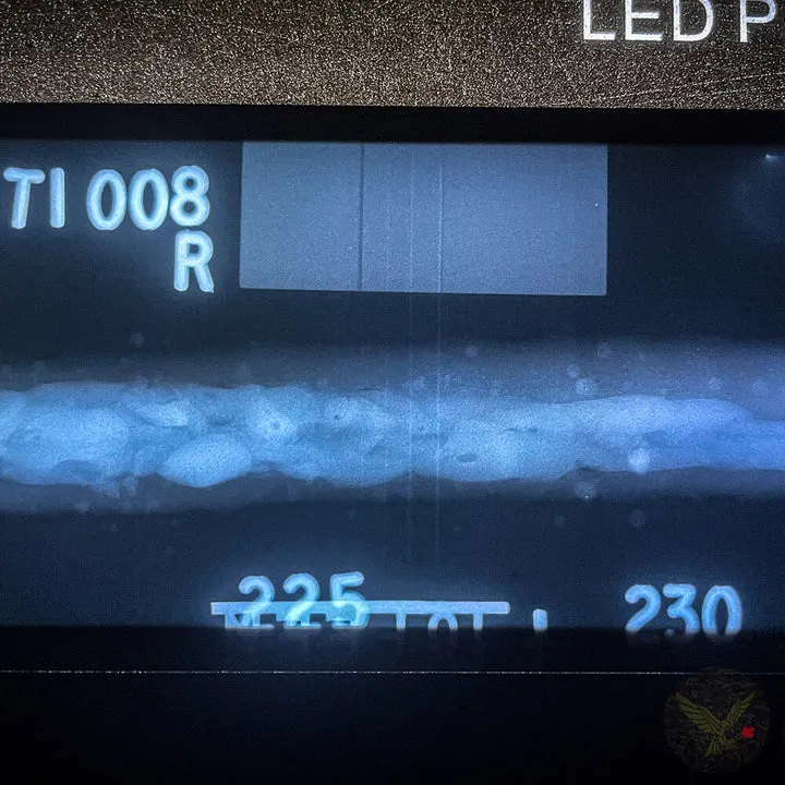 Weld radiograph on a film viewer showing identification markers