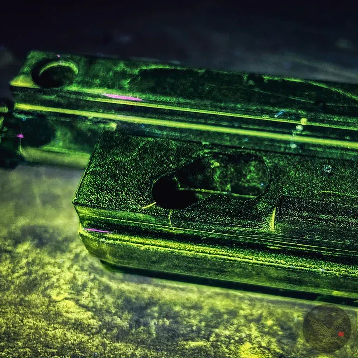 Fluorescent magnetic particle indications on a machined steel component